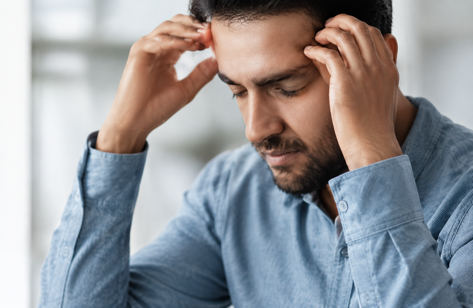Man holding his head in migraine pain